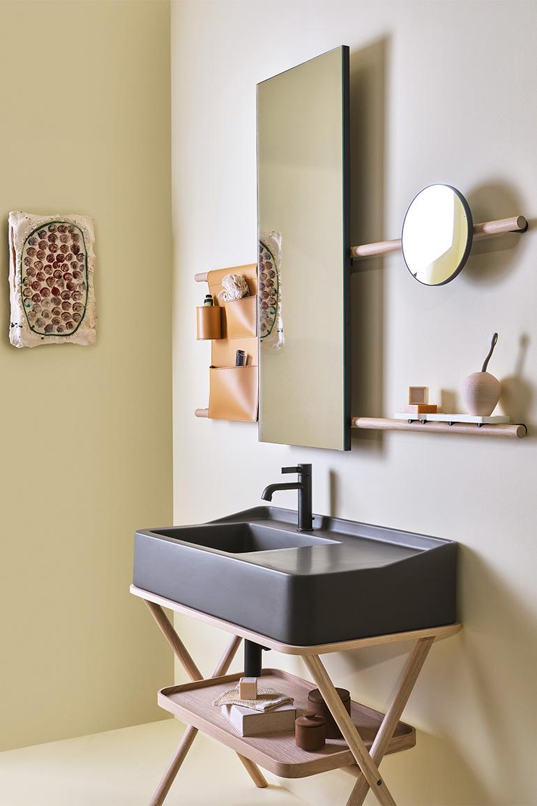 Nell’immagine, Siwa di Ceramica CIELO, disegnato da Andrea Parisio e Giuseppe Pezzano, il mobile con lavabo in ceramica nella finitura Fango della gamma cromatica “Terre di Cielo” abbinato a un vassoio e una struttura in legno finitura Rovere Naturale. A parete specchiera Siwa nella versione rettangolare, con struttura in legno in finitura Rovere Naturale e Sacca portaoggetti in cuoio naturale.