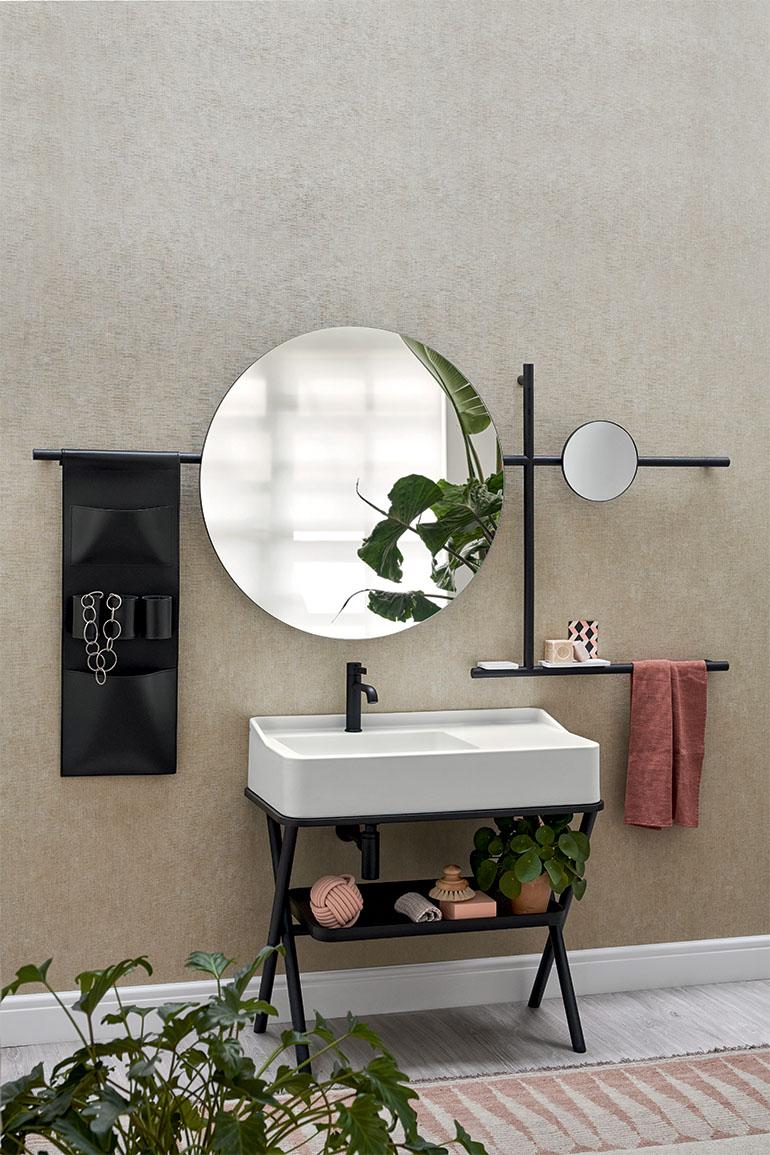 Nell’immagine, Siwa di Ceramica CIELO, disegnato da Andrea Parisio e Giuseppe Pezzano, il mobile con lavabo in ceramica in finitura Talco della gamma cromatica “Terre di Cielo” abbinato a un vassoio e una struttura in legno in finitura Rovere Nero. A parete specchiera Siwa nella versione tonda, con struttura in legno in finitura Rovere Nero e Sacca portaoggetti in cuoio naturale nel colore Nero.