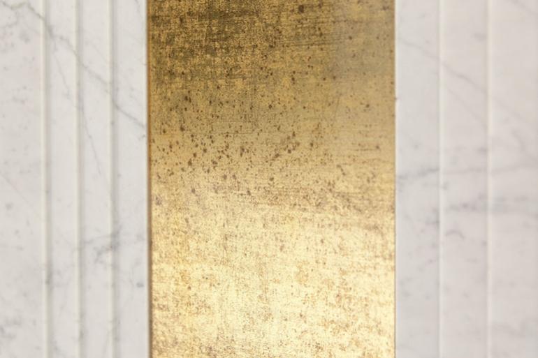 Bianco Carrara e Vetro &ldquo;Crystal&rdquo; -  La superficie &egrave; realizzata con marmo Bianco Carrara e vetro dorato. La lastra di pietra lucida &egrave; stata sagomata con tre piccoli scalini rifiniti con levigatura satinata.